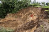 Warga melihat tebing yang longsor di Kampung Bojongkaung, Nagrak, Kabupaten Sukabumi, Jawa Barat, Selasa (15/01/2019). Hujan deras yang melanda wilayah tersebut menyebabkan tebing sepanjang 200 meter longsor serta mengakibatkan puluhan makam terseret dan tertimbun tanah longsor. ANTARA JABAR/Nurul Ramadhan/agr. 