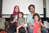 Dua Pekerja Migran Indonesia (PMI) asal Jawa Timur yaitu Wahyudi (kanan) dan istrinya Widya Anisa Putry memperlihatkan paspor milik mereka saat mengikuti pendataan oleh BP3TKI setibanya di Dinas Sosial Provinsi Kalbar di Pontianak, Jumat (4/1/2019) malam. BP3TKI Pontianak mencatat selama 2018 pihaknya telah memfasilitasi 2.132 PMI ilegal yang dipulangkan Pemerintah Malaysia melalui PLBN Entikong Kabupaten Sanggau karena terjerat kasus cop imigrasi palsu, paspor masa berlaku habis, tidak mempunyai kontrak dan visa kerja. ANTARA FOTO/Reza Novriandi/jhw