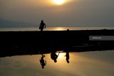 Wisatawan menikmati momen matahari terbit di Pantai Boom, Banyuwangi, Jawa Timur, Selasa (1/1/2019). Kabupaten Banyuwangi yang terletak di ujung timur pulau Jawa itu, menjadi salah satu tempat fovorit untuk menyaksikan matahari terbit pertama kali di pulau Jawa pada awal tahun 2019. Antara Jatim/Budi Candra Setya/ZK.