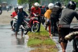 Pengendara mendorong motornya yang mogok di Jalan Raya yang terendam banjir di Porong, Sidoarjo, Jawa Timur, Minggu (20/1/2019). Banjir yang diakibatkan curah hujan tinggi sejak beberapa hari terakhir menyebabkan terganggunya aktivitas transportasi di Jalan Raya Porong. Antara Jatim/Umarul Faruq/ZK.