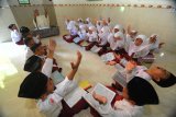 Siswa kelas satu menghafal Alquran menggunakan metode gerakan tangan di SDN Kowel 3, Pamekasan, Jawa Timur, Minggu (13/01/2019). Salah satu program unggulan sekolah peraih Adiwiyata Nasional itu mewajibkan siswanya hafal minimal satu juz Alquran ketika lulus dari sekolah tersebut. Antara Jatim/Saiful Bahri/zk