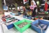 Pedagang menimbang ikan di lapaknya yang sepi pembeli di area pasar tradisional Setonobetek, Kota Kediri, Jawa Timur, Rabu (23/1/2019). Pedagang mengaku tiga hari terakhir pasokan ikan laut dari pantai selatan Jawa hanya tersedia jenis tuna dengan jumlah terbatas karena cuaca ekstrim yang mengakibatkan kenaikan harga tuna dari normalnya Rp30.000 menjadi Rp40.000 per kilogram. Antara Jatim/Prasetia Fauzani/ZK