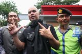 Polisi mengawal musisi Ahmad DhaniÂ (tengah) yang menjalani proses Pelimpahan Tahap II di Kejaksaan Negeri Surabaya, Jawa Timur, Kamis (17/1/2019). DitreskrimsusÂ Polda Jawa Timur menyerahkan barang bukti serta tersangka Ahmad Dhani atas kasus dugaan pencemaran nama baik dengan jeratan Undang-Undang Informasi dan Transaksi Elektronik (ITE) ke Kejari Surabaya namun terhadap tersangka tidak dilakukan penahanan. Antara Jatim/Didik Suhartono/ZK