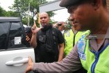 Polisi mengawal musisi Ahmad Dhani (kiri) yang menjalani proses Pelimpahan Tahap II di Kejaksaan Negeri Surabaya, Jawa Timur, Kamis (17/1/2019). Ditreskrimsus Polda Jawa Timur menyerahkan barang bukti serta tersangka Ahmad Dhani atas kasus dugaan pencemaran nama baik dengan jeratan Undang-Undang Informasi dan Transaksi Elektronik (ITE) ke Kejari Surabaya namun terhadap tersangka tidak dilakukan penahanan. Antara Jatim/Didik Suhartono/ZK