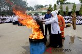 Pelajar memadamkan api secara tradisional yang dibimbing petugas pada sosialisasi penanggulangan bencana kebakaran di SMP Negeri 2, Banda Aceh, Aceh, Senin (21/1/2019). Dinas Pemadam Kebakaran dan Penyelamatan (DPKP) memberikan pengetahuan cara pemadaman api menggunakan peralatan sederhana, racun api dan penanganan kebakaran kompor gas agar para pelajar mempunyai kemampuan dini menghadapi bencana kebakaran. (Antara Aceh/Irwansyah Putra)