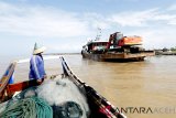 Nelayan melihat alat berat yang sedang melakukan pengerukan muara krueng (sungai) Aceh yang dangkal di Banda Aceh, Aceh, Selasa (8/1/2019). Pengerukan muara untuk mengatasi kedangkalan dilakukan para nelayan dan pemilik kapal dengan cara swadaya guna memudahkan keluar masuk kapal ke Daerah Aliran Sungai (DAS) Aceh. (Antara Aceh/Irwansyah Putra)