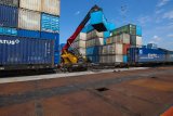 Petugas mengoperasikan alat berat untuk mengangkat kontainerÂ ke kereta api kargo di Stasiun Kalimas, Surabaya, Jawa Timur, Senin (21/1/2019). PT Kereta Api Indonesia (KAI) Daop 8 Surabaya mencatat telah mengangkut berbagai komiditi dan barang sebanyak 2.632.052 ton sepanjang tahun 2018, hal tersebut meningkat sebesar 5,86 persen dibandingkan tahun 2017 yang mencapai angka 2.486.425 ton. Antara Jatim/Didik Suhartono/ZK.