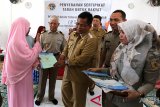 Wali Kota Banda Aceh Aminullah Usman (tiga kanan) didampingi Kakanwil BPN Aceh Saiful (dua kiri) menyerahkan sertifikat tanah kepada warga di Banda Aceh, Aceh, Selasa (15/1/2019). Pemerintah melalui Kementerian Agraria dan Tata Ruang/Badan Pertanahan Nasional (BPN) menargetkan selama 2014 hingga 2019 dapat mengeluarkan 25 juta sertifikat tanah guna mengatasi persoalan konflik agraria dalam pembangunan infrastruktur. (Antara Aceh/Irwansyah Putra)