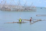 Nelayan menyiapkan bambu untuk memperbaiki bagan yang rusak di Pantai Desa Montok, Pamekasan, Jawa Timur, Rabu (23/01/2019). Dalam tiga hari terakhir nelayan di daerah itu tidak melaut menyusul angin dan ombak besar. Antara Jatim/Saiful Bahri/ZK.