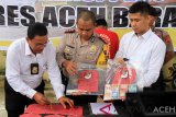 Personel Kepolisian Polres Aceh Barat memperlihatkan tersangka dan barang bukti pencurian dengan kekerasan (Curas) saat gelar perkara di Mapolres Aceh Barat, Senin, (21/1/2019). Polres Aceh Barat meringkus tersangka Curas antar Kabupaten dengan inisial AR (29) dan mengamankan barang bukti uang tunai sebanyak Rp 29.000.000, satu unit sepeda motor jenis Honda beat dan 50 mayam atau 165 gram emas perhiasan, atas perbuatannya tersangka dijerat dengan pasal 365 ayat 1 Jo 362 KUHP dengan ancaman 9 tahun penjara. (Antara Aceh/Syifa Yulinnas)