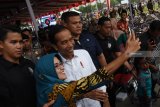 Presiden Joko Widodo (tengah) berswafoto dengan warga saat melakukan kunjungan kerja (kunker) di Alun-alun Ponorogo, Jawa Timur, Jumat (4/1/2019). Dalam kunjungan kerjanya di Ponorogo, Presiden Joko Widodo meninjau proyek pembangunan Waduk Bendo dan menyerahkan sertifikat tanah untuk rakyat. Antara Jatim/Siswowidodo/ZK.