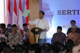 Presiden RI Joko Widodo menunjukkan sertifikat kepada warga saat penyerahan sertifikat untuk rakyat di Pendopo Sasana Adhi Praja, Blitar, Jawa Timur, Rabu (3/1/2019). Penyerahan 2.500 sertifikat kepada warga didaerah itu merupakan bagian dari program pemerintah dalam hal penerbitan sertifikat bagi takyat yang pada tahun 2019 ini ditargetkan sebanyak 9 juta sertifikat lagi dirampungkan. Antara Jatim/Irfan Anshori/ZK.