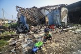 Dua orang anak bermain di depan rumah yang rusak akibat angin puting beliung di Perumahan Rancaekek Permai 2, Kabupaten Bandung, Jawa Barat, Sabtu (12/1/2019).  Angin puting beliung yang melanda beberapa titik di Kabupaten Bandung pada Jumat (11/1) sore tersebut membuat sekitar empat rumah rusak berat, dan 196 rumah rusak ringan. ANTARA JABAR/Raisan Al Farisi/agr. 