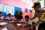 Personel Babinsa Koramil 23 Beringin Kodim 0204/DS Sertu Junaedi (kiri) bersama anggota Babinkamtibmas Polsek Beringin Aipda Kornelius Panjaitan (kanan) membimbing sejumlah siswa ketika mengajar di SD Negeri 101922 Beringin, Lubuk Pakam, Kabupaten Deli Serdang, Sumatera Utara, Senin (21/1/2019). Kegiatan tersebut merupakan upaya membangun sinergitas dan kekompakan antara TNI - Polri dalam pengabdiannya kepada masyarakat khususnya untuk memberi inspirasi semangat belajar kepada siswa. (Antaranews  Sumut) - Septianda Perdana