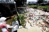 Warga beraktivitas disamping tumpukan sampah rumah tangga yang menyumbat aliran anak Sungai Ciliwung Kali Baru, Bojong Gede,  Bogor, Jawa Barat, Kamis (10/1/2019). Warga mengeluhkan sampah yang menumpuk di sungai tersebut yang membuat aliran sungai tersumbat dan jika hujan deras menyebabkan air dan sampah meluap ke jalan. ANTARA JABAR/Yulius Satria Wijaya/agr. 