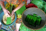 Perajin menyelesaikan pembuatan tempe menggunakan kemasan daun pisang di Gintangan, Banyuwangi, Jawa Timur, Kamis (10/1/2019).  Tempe menggunakan daun pisang sebagai kemasan yang dijual mulai harga Rp250-Rp500 itu tetap dipertahankan karena faktor cita rasa, kesehatan dan ramah lingkungan dibandingkan menggunakan plastik. Antara Jatim/Budi Candra Setya/ZK