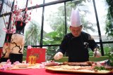 Juru masak menyajikan makanan khas saat menyambut Tahun Baru Cina di JW Marriott Surabaya, Jawa Timur, Rabu (23/1/2019). Berbagai makanan khas ditampilkan saat menyambut tahun Baru Imlek dengan simbol Babi Tanah dalam astrologi CIna. Antara Jatim/Zabur Karuru