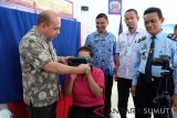 Kepala Dinas Kependudukan dan Pencatatan Sipil Medan OK Zulfi (kiri) membantu proses perekaman pembuatan KTP elektronik kepada warga binaan pemasyarakatan wanita, disaksikan Kepala Dinas Kependudukan dan Pencatatan Sipil Sumut Ismael Parenus Sinaga (kedua kiri) Anggota KPU Sumut Herdensi Adnin (ketiga kiri) dan Kepala Seksi Registrasi dan Klasifikasi Lembaga Pembinaan Khusus Anak Kelas I Medan Daulat Siregar (kanan), di Medan, Sumatera Utara, Kamis (17/1/2019). Perekaman KTP elektronik kepada warga binaan pemasyarakatan tersebut bertujuan untuk pendataan yang akan dimasukan kedalam Daftar Pemilih Tambahan (DPTb) pada Pemilu 17 April 2019. (Antara Sumut/Irsan)