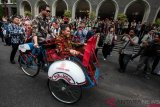 Menteri Energi dan Sumber Daya Mineral (ESDM) Ignasius Jonan (kiri) bersama Rektor Universitas Gadjah Mada (UGM) Panut Mulyono (kanan depan) mencoba becak listrik saat diluncurkan di Balairung UGM, Sleman, DI Yogyakarta, Jumat (18/1/2019). UGM bekerja sama dengan PT PLN mengembangkan 15 prototype becak listrik dengan penggerak motor listrik 1500 watt 48 V dan diberikan kepada paguyuban pengemudi becak kawasan Bulak Sumur. ANTARA FOTO/Andreas Fitri Atmoko/foc. 