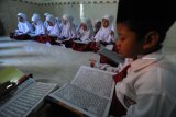 Siswa kelas satu menghafal Alquran menggunakan metode gerakan tangan di SDN Kowel 3, Pamekasan, Jawa Timur, Minggu (13/01/2019). Salah satu program unggulan sekolah peraih Adiwiyata Nasional itu mewajibkan siswanya hafal minimal satu juz Alquran ketika lulus dari sekolah tersebut. Antara Jatim/Saiful Bahri/zk