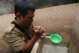 Petugas Dinas Kesehatan memeriksa keberadaan jentik nyamuk pada tandon air di kawasan endemik wabah Deman Berdarah Dengue (DBD) di Desa Wonocatur, Kediri, Jawa Timur, Selasa (29/1/2019). Sidak di permukiman warga tersebut sebagai sosialisasi mencegah perkembangbiakan nyamuk pembawa virus Aedes Aegypti penyebab DBD. Antara JatimPrasetia Fauzani/ZK.