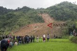 Warga melihat reruntuhan longsor di kampung Cimapag, Desa Sirnaresmi, Kecamatan Cisolok, Kabupaten Sukabumi, Jawa Barat, Selasa (1/1/2019). Dalam peristiwa tersebut Sebanyak 63 orang selamat, delapan meninggal dan 26 orang belum ditemukan. ANTARA JABAR/M Agung Rajasa/agr.