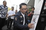 Gubernur Jawa Barat Ridwan Kamil menandatangani poster saat pembukaan pameran dan peluncuran buku fotografi ARKE - Kilas Balik Jabar 2018, di Galeri Foto Antara Jawa Barat, Jalan Braga Bandung, Jawa Barat, Kamis (24/1/2019). Pameran foto hasil karya pewarta foto Antara Jabar yang menampilkan 248 karya terbaik sepanjang 2017-2018 berlangsung hingga 24 Februari 2019. ANTARA JABAR/Adeng Bustomi/agr. 