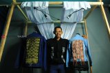 Pelaku ekonomi kreatif (Ekraf) Pontianak Harivo Santoso memperlihatkan dua jaket denim tenun songket di Studio Oy di Pontianak, Kalimantan Barat, Jumat (18/1/2019). Jaket denim menggunakan kain tenun dan songket khas Kalbar yang dirancang Harivo dan telah didaftarkan ke Kemenkumham untuk mendapatkan Hak Atas Kekayaan Intelektual (HaKI) tersebut dijual seharga Rp350 ribu hingga Rp500 ribu per helai. ANTARA FOTO/Jessica Helena Wuysang