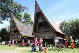 Kelompok kesenian menampilkan tarian adat multi etnis dengan latar belakang rumah adat Batak Toba di Museum Batak TB Silalahi Cente, Toba Samosir, Sumatera Utara, Rabu (23/1/2019). Museum Batak yang menyimpan ratusan koleksi benda bersejarah dan juga rumah adat Batak Toba berumur ratusan tahun tersebut merupakan salah satu objek wisata sejarah di Toba Samosir.(Antara Sumut/Irsan)
