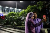 Pasangan pengantin berswafoto seusai mengikuti acara nikah massal di Jalan Thamrin, Jakarta, Senin (31/12/2018). Pemprov DKI mengadakan acara menyambut malam pergantian tahun 2019 dengan menyelenggarakan Car Free Night, acara nikah massal dan berbagai hiburan panggung. ANTARA FOTO/Putra Haryo Kurniawan/pras.