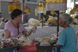 Pedagang melayani wisatawan saat berbelanja di Pasar Tradisional Sindu, Denpasar, Bali, Selasa (29/1/2019). Pasar tradisional yang menjadi percontohan pasar sehat dan higenis tersebut ditargetkan sebagai salah satu destinasi wisata dalam program 
