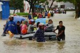 Tim relawan mengevakuasi warga korban banjir di Kelurahan Paccerakkang, Makassar, Sulawesi Selatan, Selasa (22/01/2019). Akibat hujan deras disertai angin kencang, sejumlah wilayah di Kota Makassar terendam banjir. ANTARA FOTO/Sahrul Manda Tikupadang/aww.