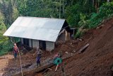 Warga membersihkan halaman rumah yang terkena longsor di Desa Mengening, Buleleng, Bali, Selasa (29/1/2019). Tanah longsor yang terjadi sekitar pukul 05.00 Wita tersebut menimpa rumah penduduk dan menewaskan empat warga setempat. ANTARA FOTO/Made Adnyana/nym