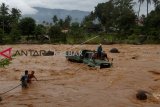 Warga berusaha menarik mobil truk pengangkut batu yang berada di tengah sungai Batang Kuranji akibat terseret banjir di Kecamatan Pauh, Padang, Sumatera Barat, Rabu (2/1/2019). Air bah yang datang dengan tiba-tiba itu menyeret truk ke tengah sungai dan supir truk berhasil selamat. ANTARA FOTO/Muhammad Arif Pribadi