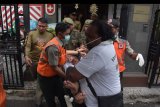 Petugas Satpol PP dan BPBD Kota Denpasar menggiring warga negara Swiss Peter Hugo Rudisuli (tengah) yang mengamuk di Kantor Konsulat Swiss di Denpasar, Bali, Kamis (31/1/2019). Warga negara Swiss itu diduga mengalami gangguan kejiwaan sehingga dibawa ke rumah sakit untuk pemeriksaan lebih lanjut. ANTARA FOTO/Nyoman Hendra Wibowo/nym