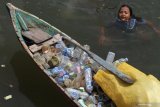 Yanti (8 tahun) berenang untuk mengumpulkan sampah plastik di sampan kecilnya di perkampungan nelayan di Kelurahan Petoaha, Abeli, Kendari, Sulawesi Tenggara, Selasa (5/2/2019). Beberapa anak SD di perkampungan setempat mengisi waktu libur sekolah dengan mengumpulkan sampah plastik sambil menjelajah Teluk Kendari untuk bisa memperoleh Rp25 ribu per hari.