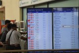 Sejumlah calon penumpang mencetak tiket di samping layar informasi penerbangan di terminal keberangkatan domestik 1B Bandara Internasional  Juanda Surabaya, Sidoarjo, Jawa Timur, Kamis (7/2/2019). Bandara tersebut ditutup sementara akibat rusaknya landasan pacu dan menyebabkan sejumlah jadwal penerbangan baik rute domestik ataupun internasional  terganggu. Antara Jatim/Zabur Karuru/ZK