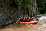 Wisatawan berpetualang arung jeram mengarungi sungai X Badeng di Songgon, Banyuwangi,Jawa Timur, Jumat (8/2/2019). Wisata Arung Jeram di Sungai X Badeng kembali beroperasi, setelah sebelumnya terganggu akibat tanah longsor di Gunung Pendil yang mengakibatkan pendangkalan debit air di sungai itu. Antara Jatim/Budi Candra Setya/ZK.