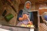 Juru masak membakar durian di rumah makan durian Dusun Sumber, Desa Wonosalam, Jombang, Jawa Timur, Sabtu (9/2/2019). Durian bakar khas Wonosalam tersebut dijual Rp 7.500 per porsi. Antara Jatim/Syaiful Arif/ZK.