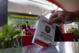 Pemilih memasukkan surat suara yang telah dicoblos ke dalam kotak suara di TPS Pilkades Desa Gandusari, Trenggalek, Jawa Timur, Sabtu (9/2). Sebanyak 132 desa dari total 152 desa di daerah itu menggelar pilkades serentak yang diikuti 327 calon kepala desa dengan total jumlah pemilih sekitar 477.000. Antara Jatim/Destyan Sujarwoko/ZK.