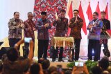 Presiden Joko Widodo (ketiga kanani) didampingi Ketua Dewan Pers Yosep Adi Prasetyo (kedua kanan), Menteri Komunikasi dan Informatika Rudiantara (kanan), Gubernur Jawa Timur Soekarwo (ketiga kiri) dan Ketua PWI Atal Sembiring Depari (kedua kiri)  serta Penanggung Jawab HPN 2019 Margiono (kiri) memukul tongtong alat musik Madura saat 