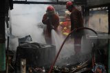 Petugas melakukan proses pembasahan pada sejumlah kios yang terbakar di Pasar Kilometer Jalan Teluk Nibung, Surabaya, Jawa Timur, Senin (11/2/2019). Sekitar 11 unit kendaraan pemadam kebakaran dari PT Pelabuhan Indonesia (Pelindo) III serta Dinas Pemadam Kebakaran Kota Surabaya dikerahkan untuk memadamkan api yang membakar sekitar 28 kios di pasar itu. Antara Jatim/Didik Suhartono/ZK