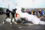 Pasukan gabungan Penanggulangan Huru-Hara (PHH) TNI - Polri menghadapi demonstran yang mengamuk memprotes hasil perhitungan suara pada simulasi pengamanan Pemilu 2019 di Mako Brigif-2 Marinir Gedangan, Sidoarjo, Jawa Timur, Senin (11/2/2019). Simulasi PPH oleh prajurit Brigir 2 Marinir bersama Brimob Polda Jatim tersebut digelar untuk melatih kesiapsiagaan dan profesional personel dalam mengamankan jalannya Pemilu Indonesia pada April 2019 mendatang. Antara Jatim/Umarul Faruq/ZK.