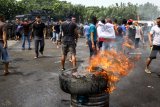 Demonstran membakar ban memprotes hasil perhitungan suara pada simulasi pengamanan Pemilu 2019 di Mako Brigif-2 Marinir Gedangan, Sidoarjo, Jawa Timur, Senin (11/2/2019). Simulasi PPH oleh prajurit Brigir 2 Marinir bersama Brimob Polda Jatim tersebut digelar untuk melatih kesiapsiagaan dan profesional personel dalam mengamankan jalannya Pemilu Indonesia pada April 2019 mendatang. Antara Jatim/Umarul Faruq/ZK.