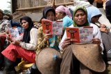 Sejumlah pengumpul sampah mengamati buku panduan saat sosialisasi Pemilu 2019 oleh KPUD Temanggung di Tempat Pembuangan Akhir (TPA) Sanggrahan, Temanggung, Jawa Tengah, Senin (11/2/2019). Kegiatan tersebut bertujuan untuk memberikan pemahaman, tata cara dan pentingnya Pemilu sekaligus untuk meningkatkan angka partisipasi pemilih. (ANTARA FOTO)