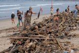 Wisatawan mancanegara turut membersihkan sampah yang terdampar akibat cuaca buruk di Pantai Kuta, Badung, Bali, Senin (11/2/2019). Hujan deras disertai angin kencang yang melanda Bali berdampak pada arus laut yang terus membawa sampah dari daerah lain dan terdampar sejumlah pantai bagian selatan Bali. ANTARA FOTO/Nyoman Hendra Wibowo/nym