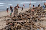 Wisatawan mancanegara turut membersihkan sampah yang terdampar akibat cuaca buruk di Pantai Kuta, Badung, Bali, Senin (11/2/2019). Hujan deras disertai angin kencang yang melanda Bali berdampak pada arus laut yang terus membawa sampah dari daerah lain dan terdampar sejumlah pantai bagian selatan Bali. (ANTARA FOTO)