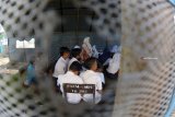  Siswa Madrasah Tsanawiyah (MTs) Fathur Rahman belajar di tenda darurat di Desa Sukorambi, Sukorambi, Jember, Jawa Timur, Selasa (12/2/2019). Sejumlah siswa MTs tersebut terpaksa belajar di tenda darurat karena ruang kelas mereka ambruk akibat hujan deras dan angin kencang. Antara Jatim/Seno/zk