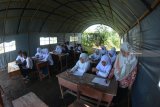  Siswa Madrasah Tsanawiyah (MTs) Fathur Rahman belajar di tenda darurat di Desa Sukorambi, Sukorambi, Jember, Jawa Timur, Selasa (12/2/2019). Sejumlah siswa MTs tersebut terpaksa belajar di tenda darurat karena ruang kelas mereka ambruk akibat hujan deras dan angin kencang. Antara Jatim/Seno/zk