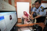 Petugas Imigrasi melayani perekaman paspor  Jamaah Calon Haji Indonesia (JCHI) yang sedang sakit di Kantor Imigrasi Kelas II Non TPI Blitar, Jawa Timur, Selasa (12/2/2019). Divisi Imigrasi Jawa Timur mempersiapkan sembilan Kantor Imigrasi untuk memproses dokumen keimigrasian bagi sebanyak 35.034 JCHI asal propinsi tersebut yang sudah dimulai sejak awal Februari, dan ditargetkan rampung pada April mendatang. Antara Jatim/Irfan Anshori/ZK